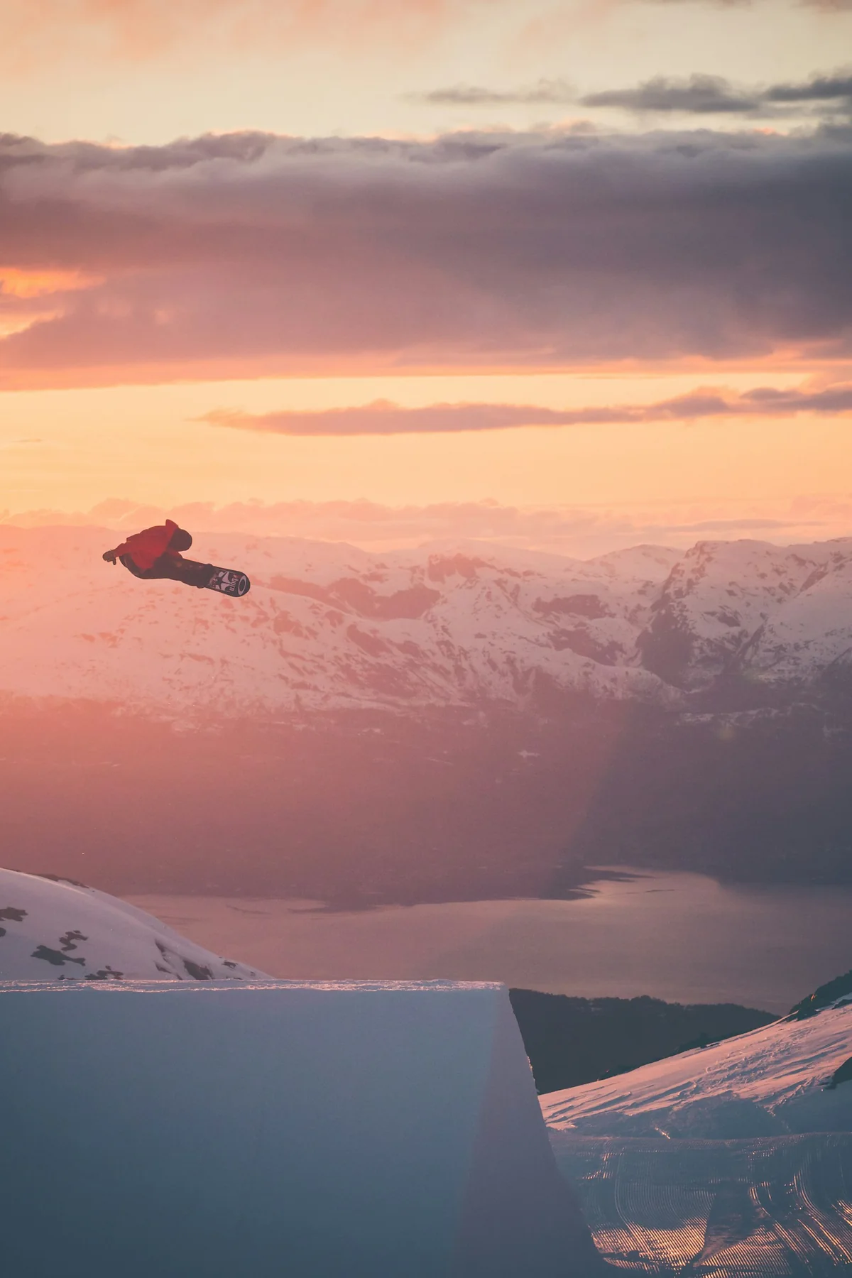 Snowboardos a levegőben, naplementében – téli sporthangulat